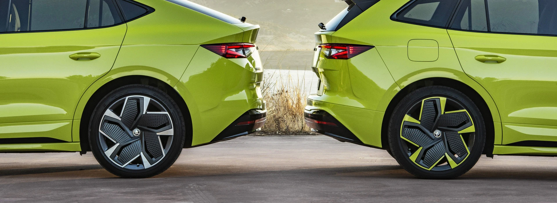 Zwei grüne Škoda-Fahrzeuge Heck an Heck mit auffälligen Felgen, Fokus auf Reifendetails.