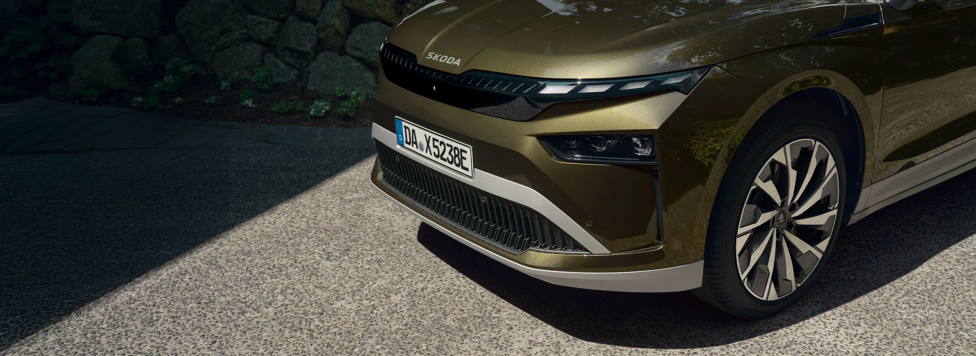 Detailansicht der Front und des Vorderrads eines grünen Škoda Enyaq.