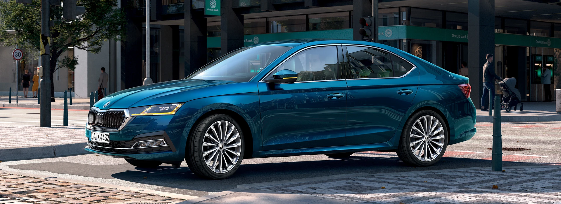 Blauer Škoda Octavia steht bei Tageslicht an einer Ampel in der Innenstadt