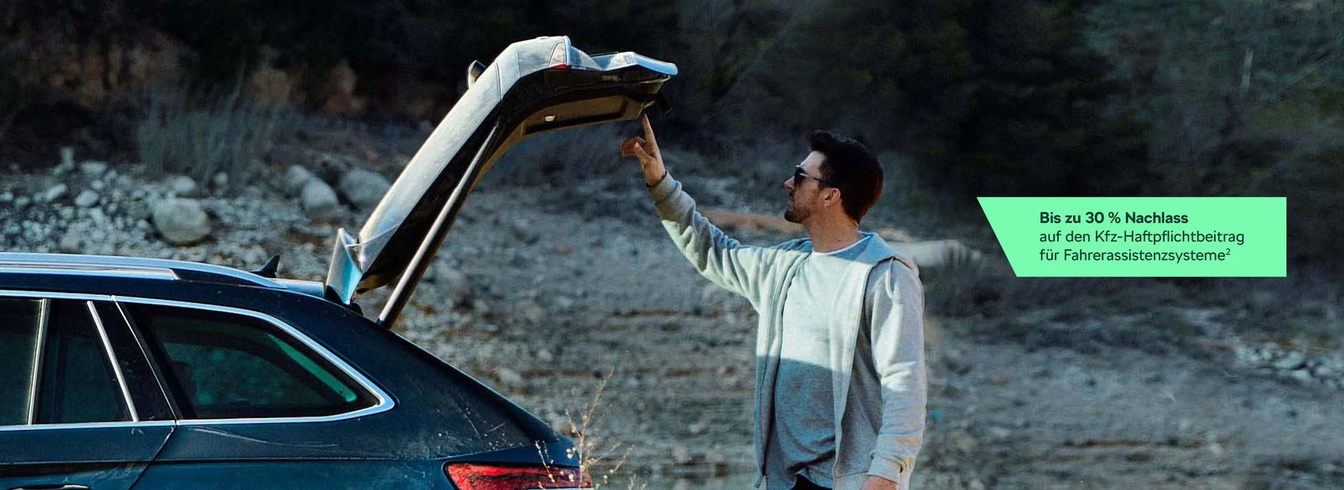 Mann schließt elektrischen Gepäckraumdeckel im Gelände mit Werbehinweis zu Rabatten