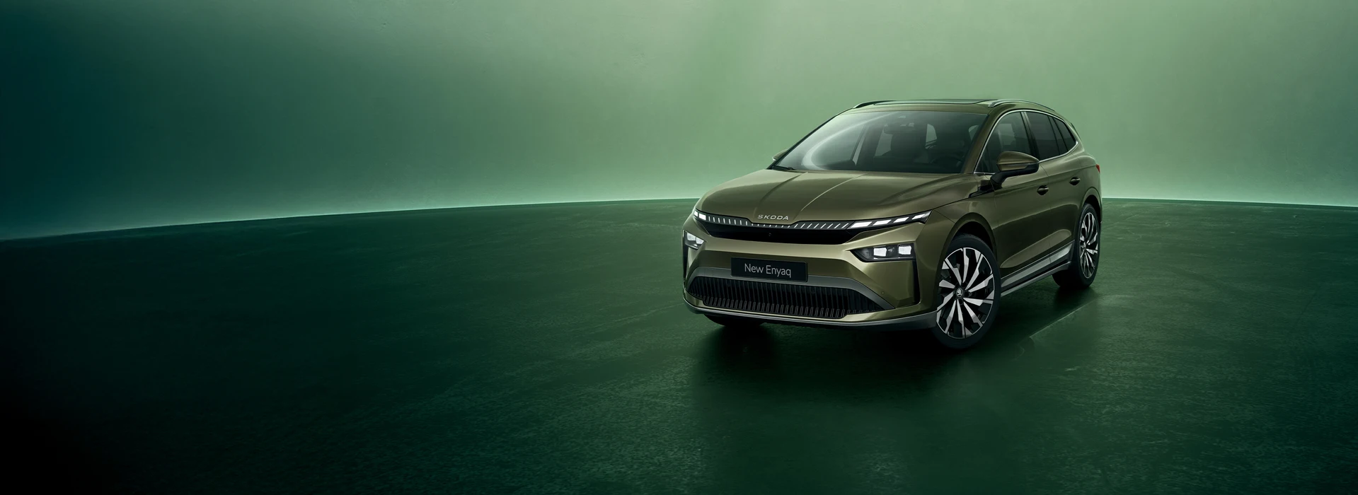 Škoda Enyaq static on a green background, ¾ front angle, Olibo Green metallic color