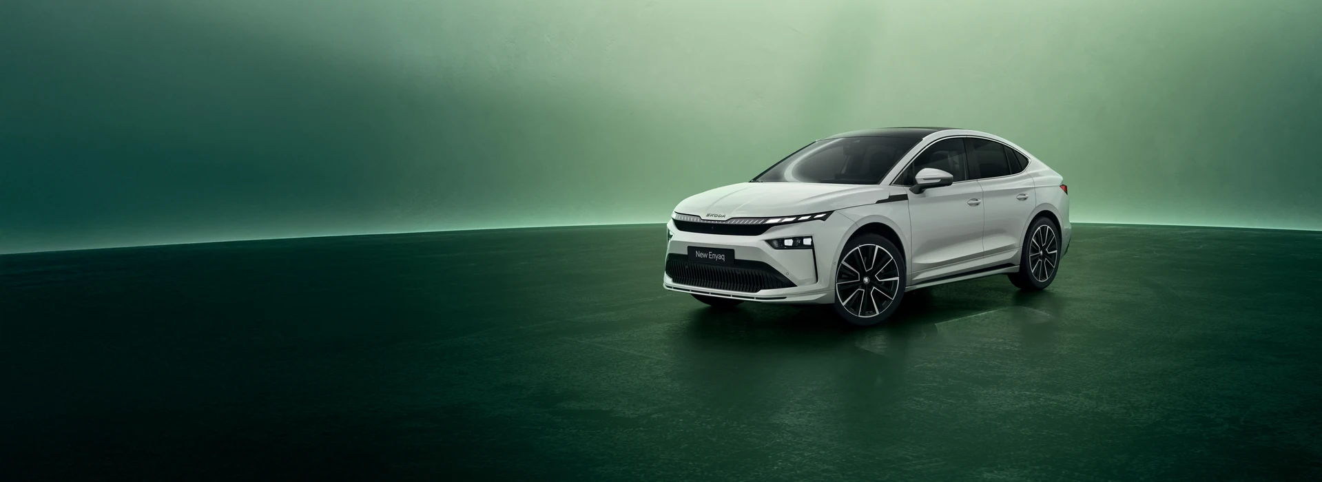 Škoda Enyaq Coupé iV static on a green background, ¾ front angle, moon white metallic color