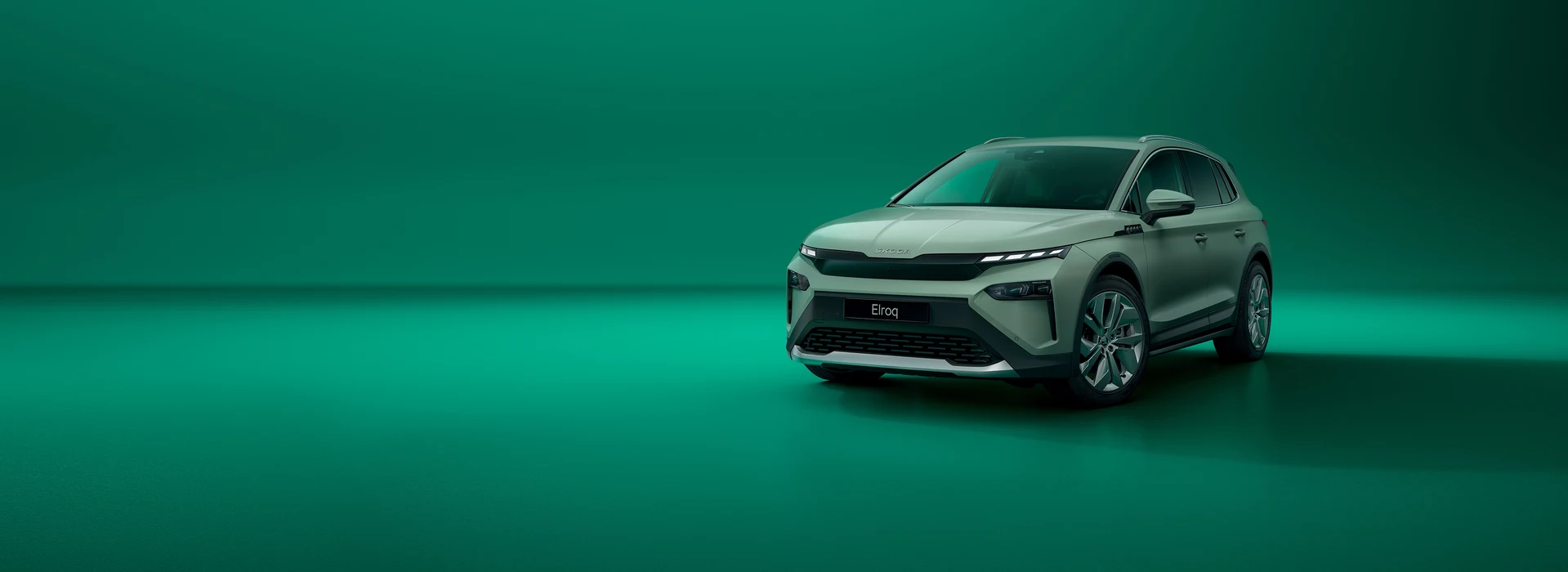 Škoda Elroq static on a green background, ¾ front angle, Timiano Green uni color