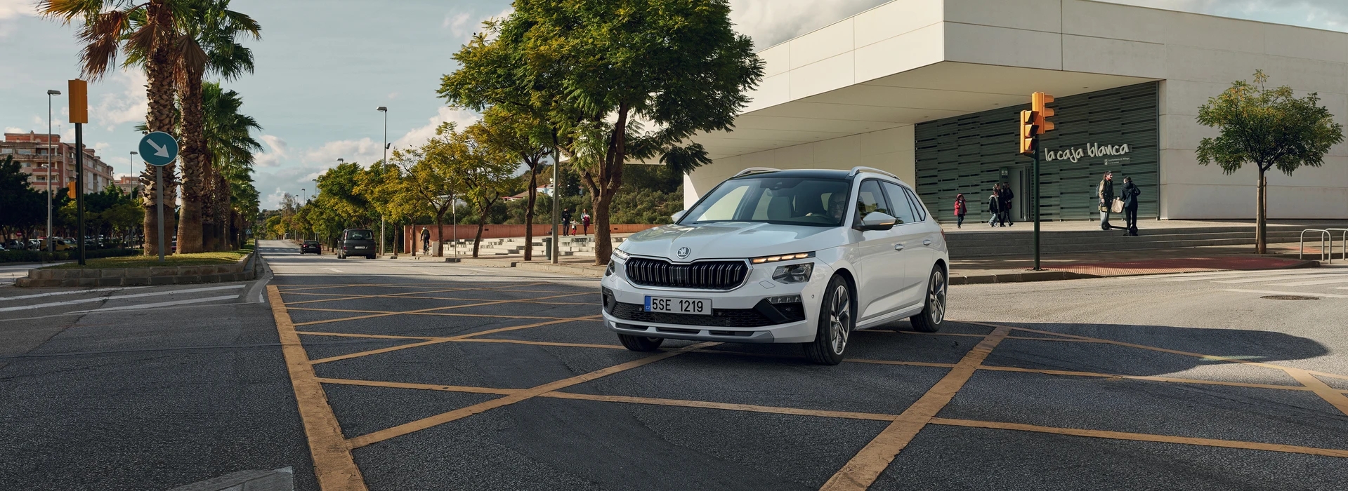 Škoda Kamiq standing in a parking lot, ¾ front angle, moon white metallic color