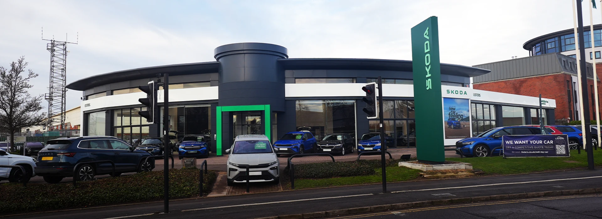 Exterior view of the Škoda Listers dealership showroom and forecourt displaying new and used cars.