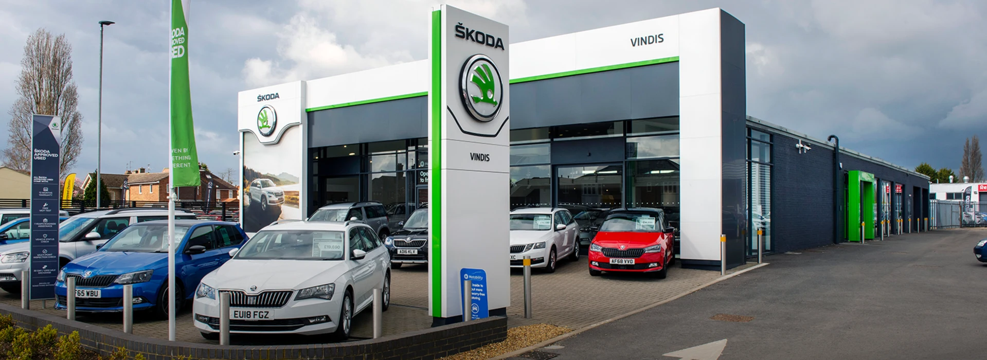Front exterior of the Škoda Vindis dealership with branded signage and cars parked outside.