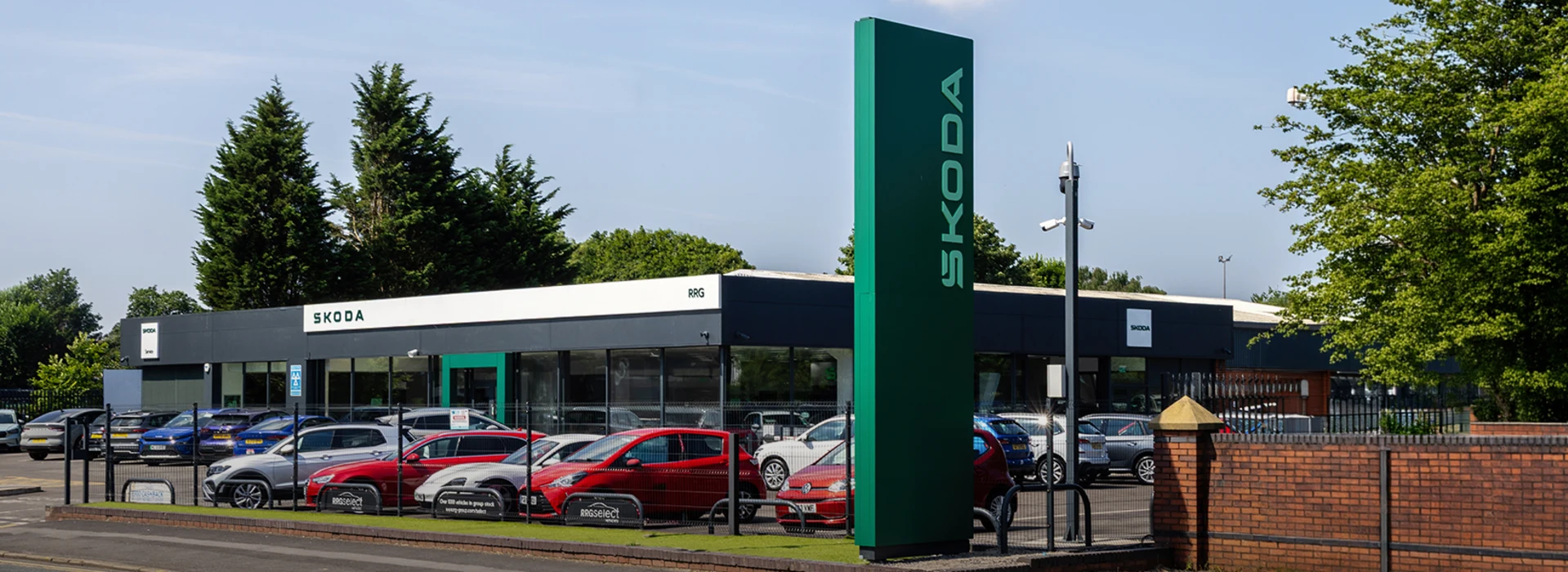Škoda RRG Rochdale dealership exterior featuring a tall green sign tower and forecourt.