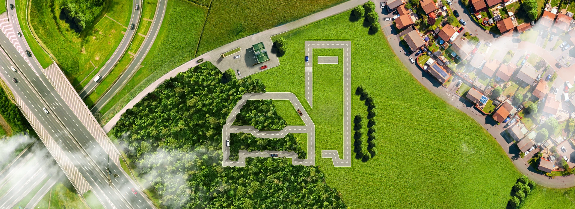 Luftaufnahme: Straßen und Wege formen stilisiertes Auto in grüner Landschaft.