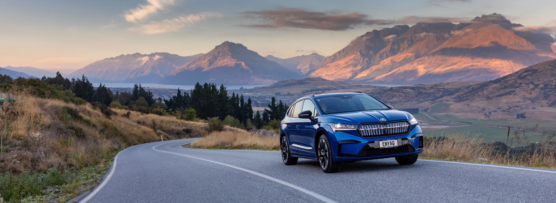 Enyaq driving with stunning south island behind