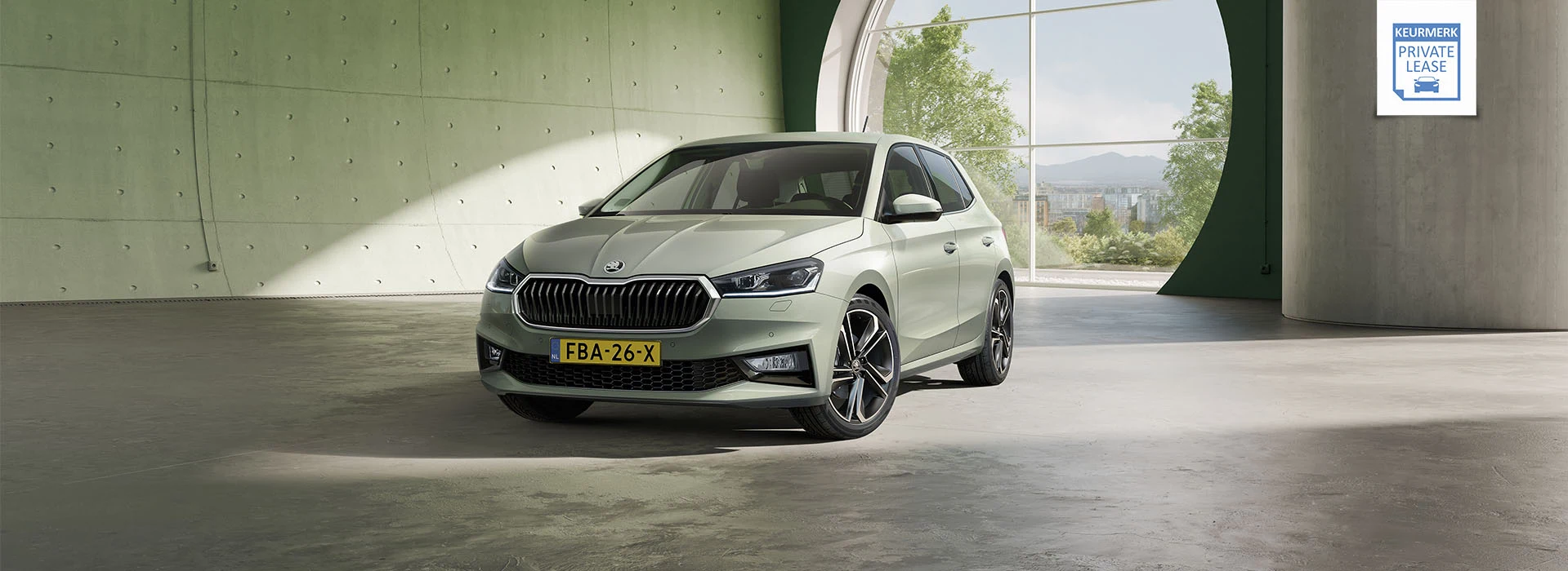 Schuin vooraanzicht van een nieuwe Škoda Fabia in groene kleur die binnen in een grote hal staat opgesteld