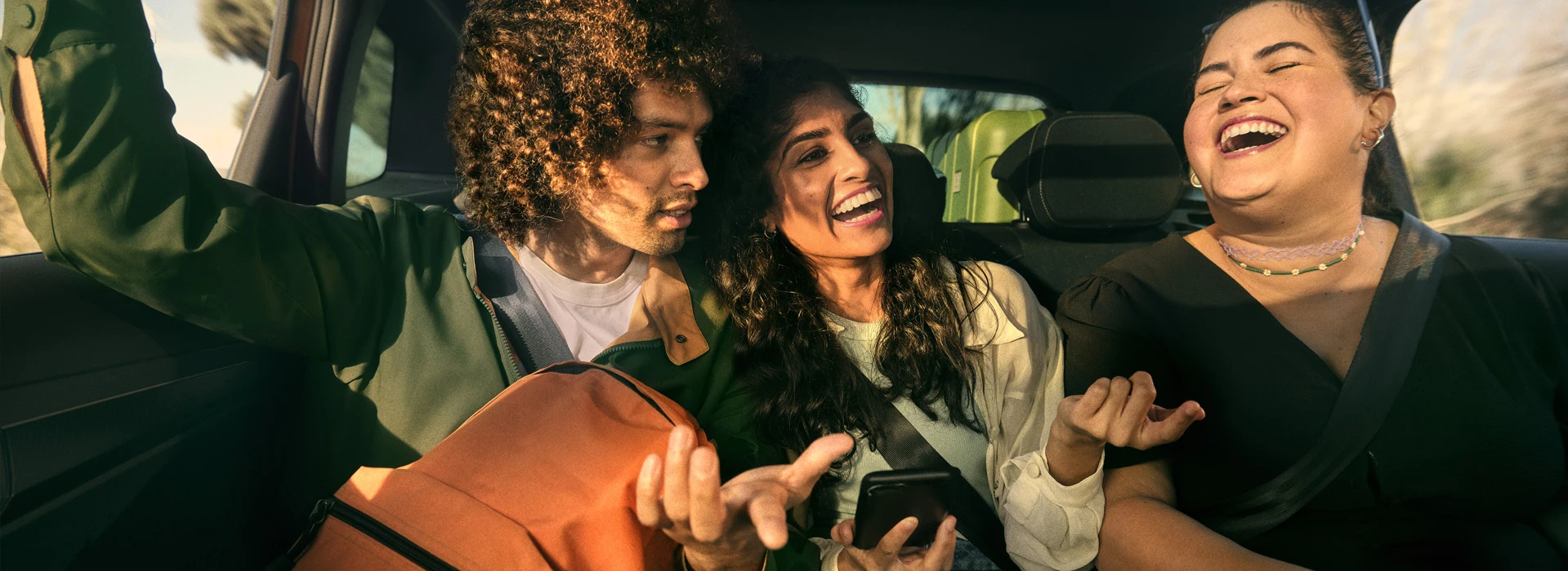 Glada ungdomar i baksätet på en Skoda