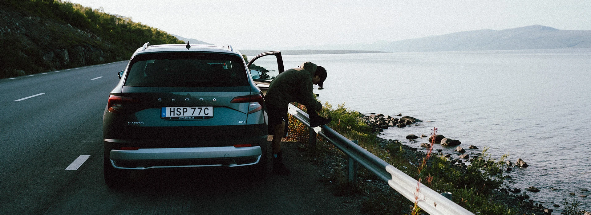Skoda bil parkerad på väg vid vatten.